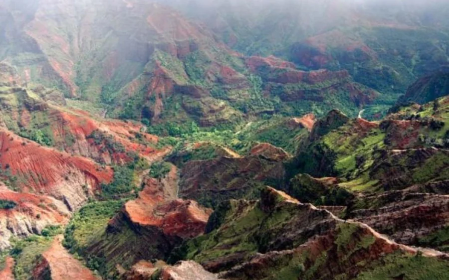 Red and green canyon ridges on Kauai seen from the air