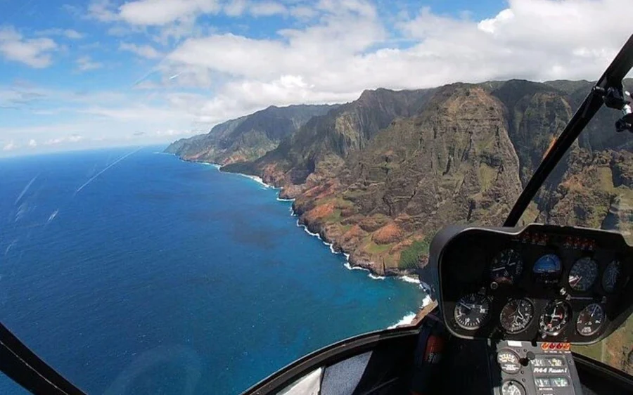 The view from a helicopter cockpit over the Na Pali coastline and the sea